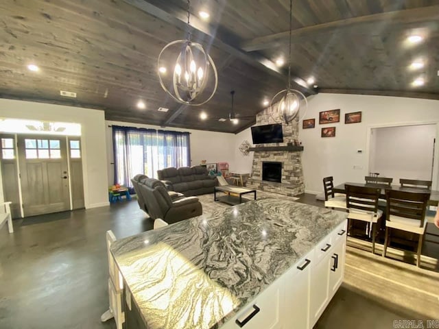 kitchen with wooden ceiling, white cabinetry, lofted ceiling, and light stone counters