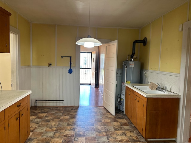 kitchen with decorative light fixtures, sink, and water heater