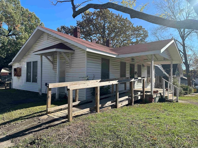 view of property exterior with a lawn and covered porch