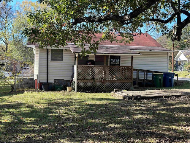 back of property with a yard and a wooden deck