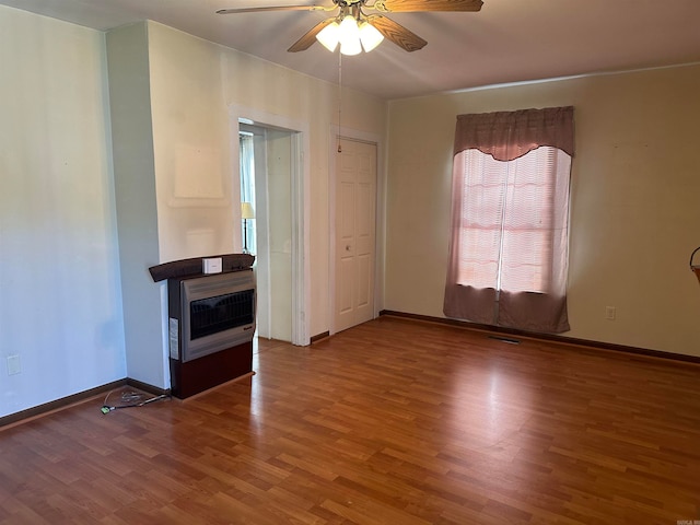 unfurnished living room with hardwood / wood-style floors, ceiling fan, and heating unit