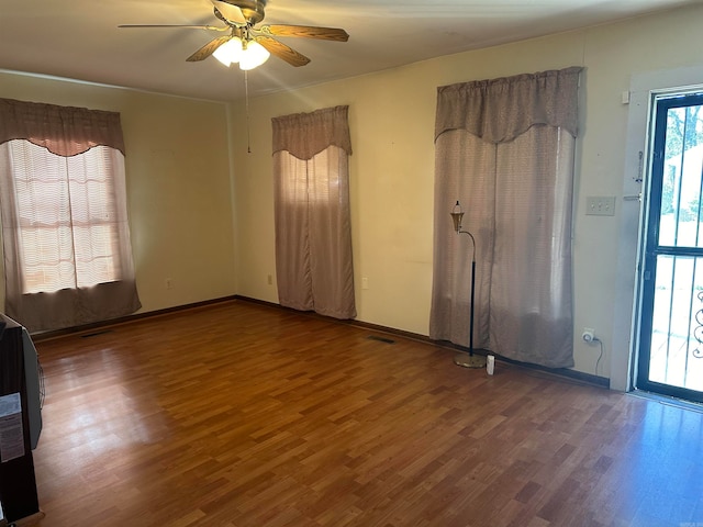 spare room featuring ceiling fan and dark wood-type flooring