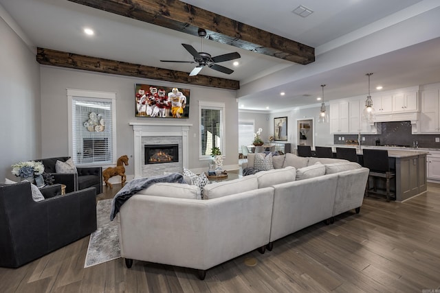 living room with beam ceiling, ceiling fan, and dark hardwood / wood-style floors