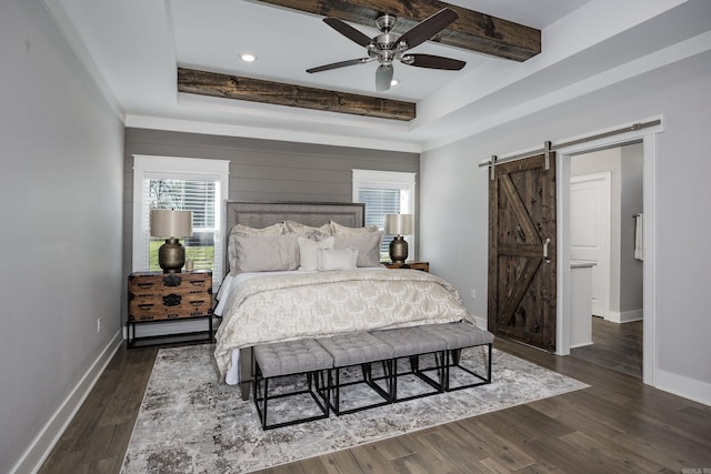 bedroom featuring dark wood-type flooring, a raised ceiling, ceiling fan, a barn door, and beam ceiling