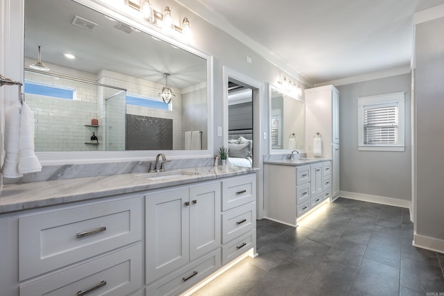 bathroom featuring a tile shower, tile patterned floors, and vanity