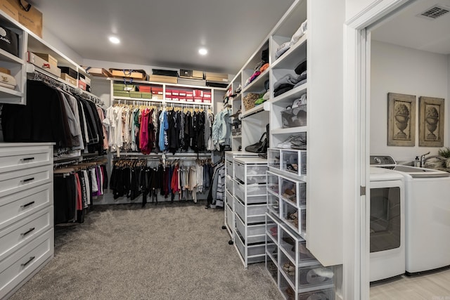 spacious closet with light colored carpet and washer and clothes dryer