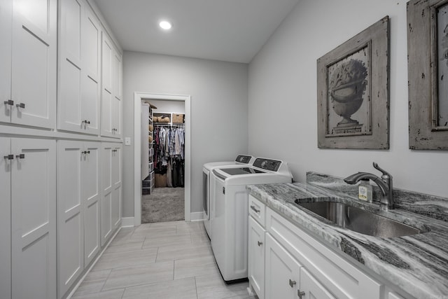 laundry room featuring separate washer and dryer, sink, and cabinets