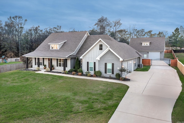 view of front of home with central air condition unit, a garage, a porch, and a front yard