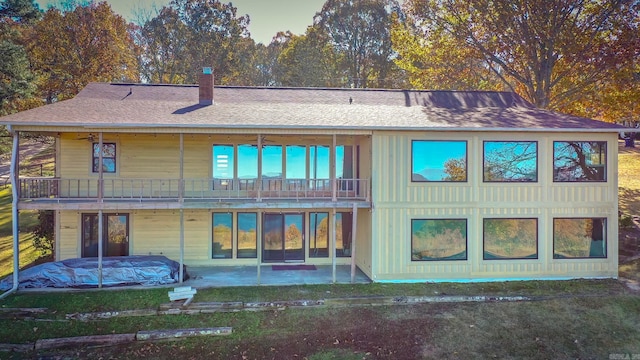 back of property featuring a balcony and a patio area