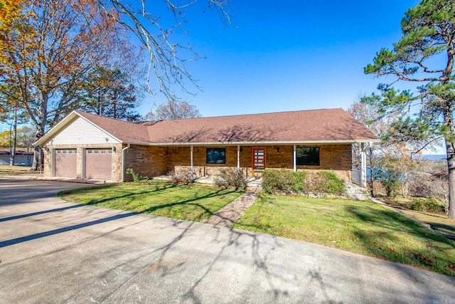 ranch-style home with covered porch, a garage, and a front lawn