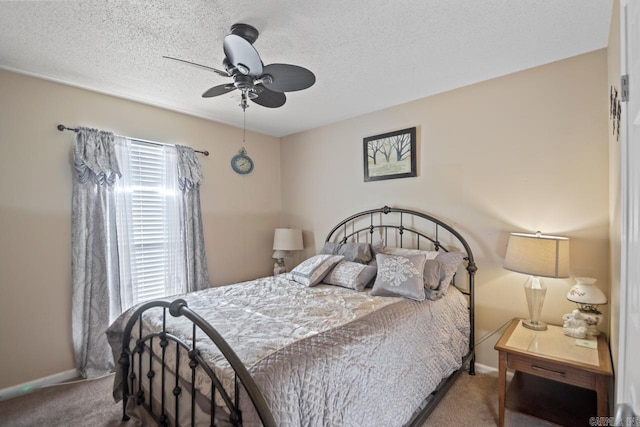 carpeted bedroom featuring ceiling fan and a textured ceiling