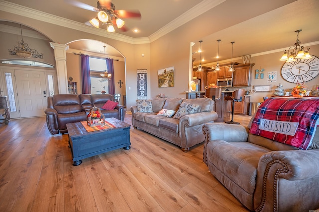 living room featuring light hardwood / wood-style flooring, ornamental molding, and ornate columns