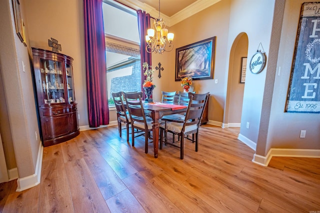 dining space with light hardwood / wood-style flooring, an inviting chandelier, and ornamental molding