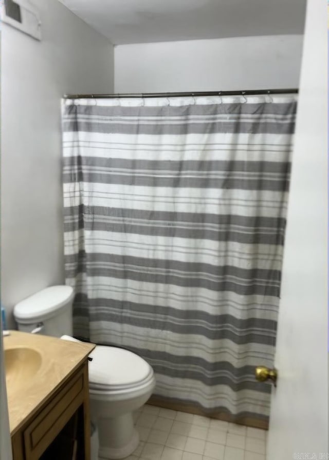 bathroom with tile patterned flooring, vanity, and toilet