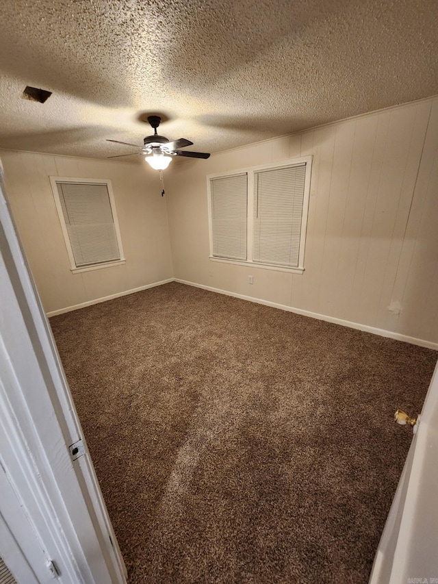 spare room featuring ceiling fan, carpet, and a textured ceiling