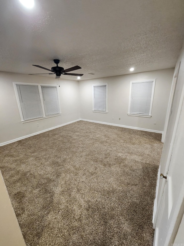 spare room featuring carpet flooring, ceiling fan, and a textured ceiling