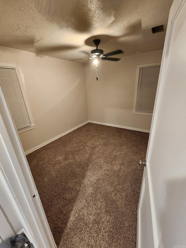 carpeted spare room featuring ceiling fan and a textured ceiling