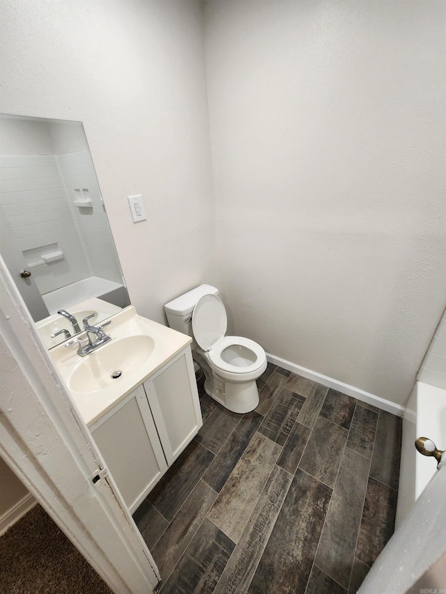 bathroom with vanity, a bathtub, toilet, and wood-type flooring