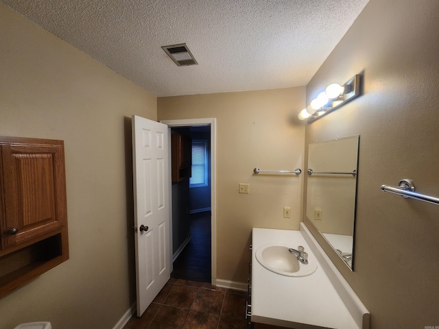 bathroom featuring tile patterned floors, vanity, and a textured ceiling