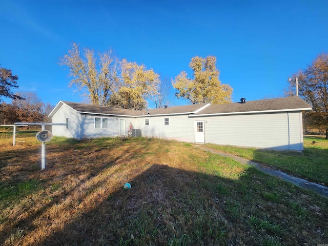 rear view of property with a yard and cooling unit