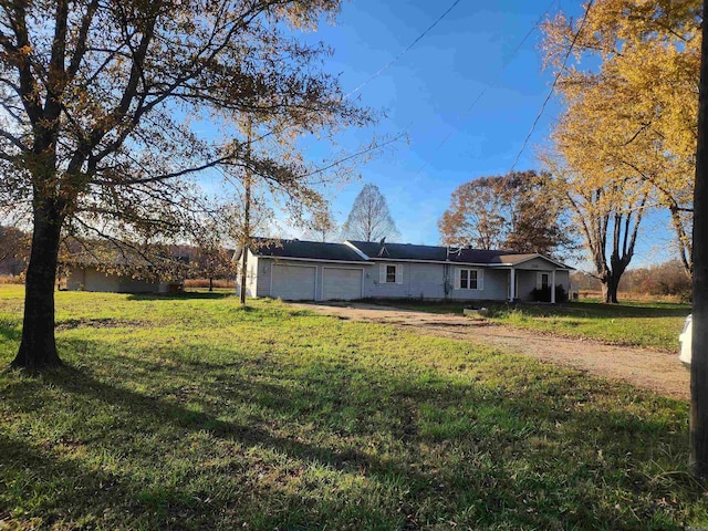 rear view of house with a lawn and a garage