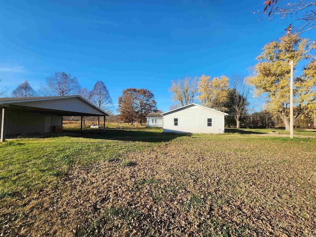 view of side of property featuring a carport and a lawn