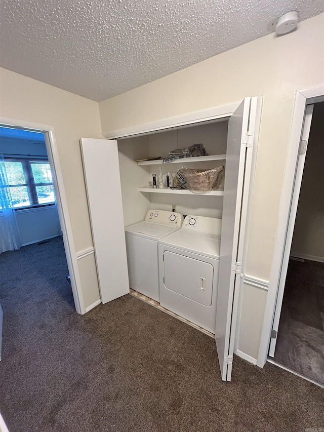 washroom featuring washer and clothes dryer, a textured ceiling, and dark colored carpet