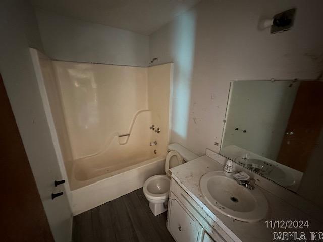 full bathroom with toilet, vanity, wood-type flooring, and tub / shower combination