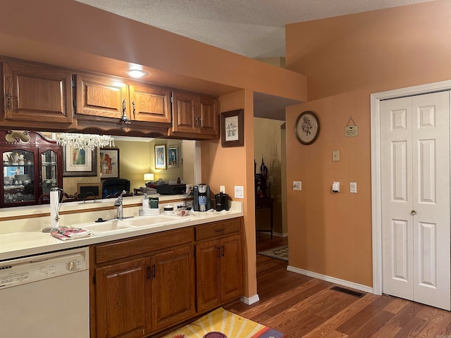 kitchen featuring white dishwasher, sink, dark wood-type flooring, and a textured ceiling