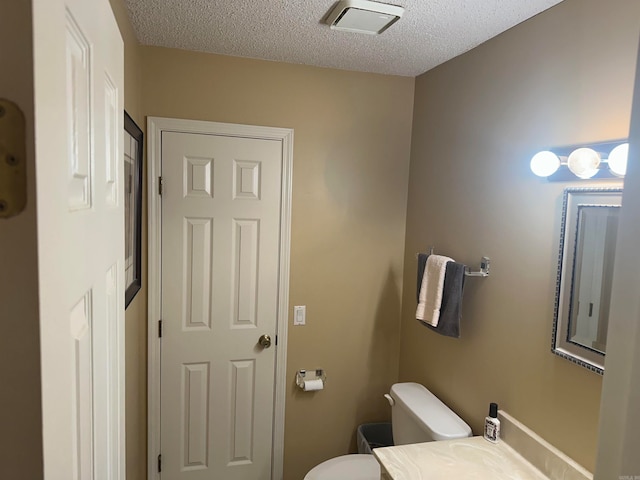 bathroom featuring a textured ceiling and toilet