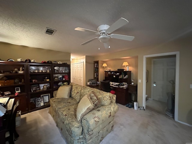 carpeted living room with a textured ceiling and ceiling fan