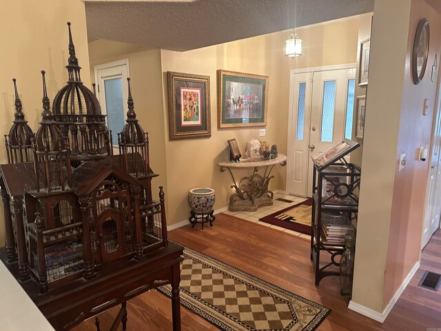 hall featuring hardwood / wood-style floors and a textured ceiling