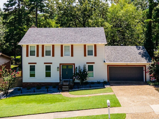 colonial house with a front yard and a garage