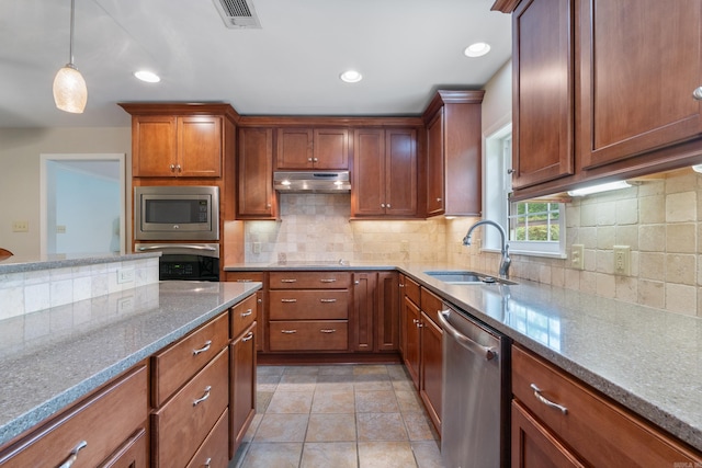 kitchen with light stone counters, sink, appliances with stainless steel finishes, and tasteful backsplash