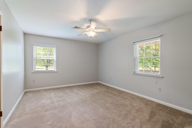 spare room with ceiling fan and light colored carpet