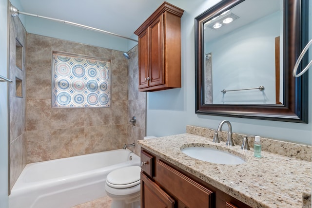 full bathroom with toilet, vanity, and tiled shower / bath