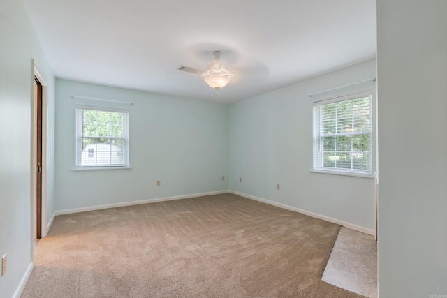 carpeted spare room featuring ceiling fan