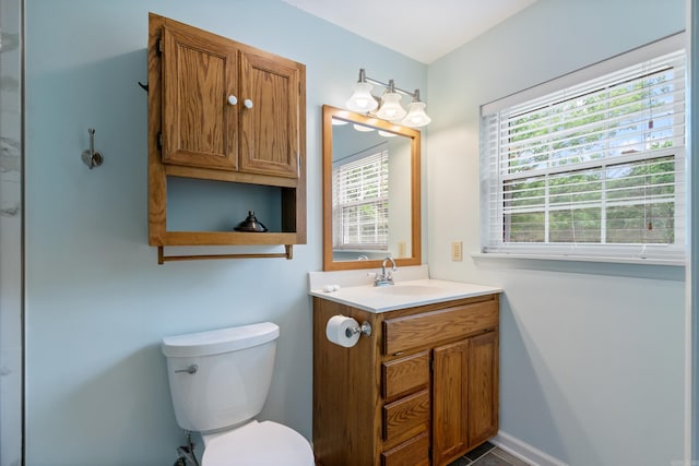 bathroom with vanity, a healthy amount of sunlight, and toilet