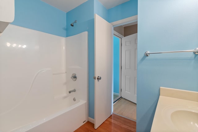 bathroom featuring hardwood / wood-style floors, shower / bathing tub combination, and sink