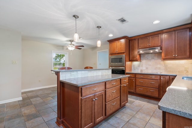 kitchen featuring pendant lighting, a center island, ceiling fan, tasteful backsplash, and stainless steel appliances