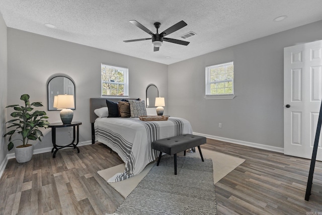 bedroom featuring ceiling fan, dark wood-type flooring, and a textured ceiling