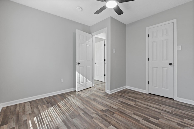 unfurnished bedroom featuring ceiling fan and dark hardwood / wood-style flooring