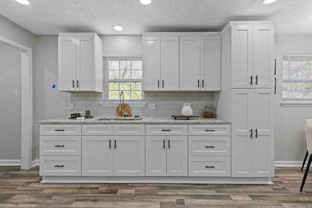 kitchen with white cabinets, dark wood-type flooring, and sink