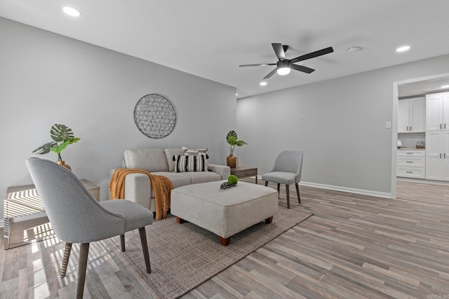 living room featuring light hardwood / wood-style flooring and ceiling fan