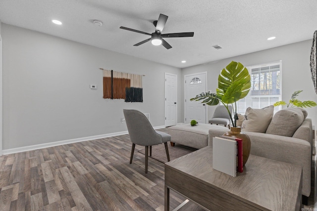 living room featuring ceiling fan, wood-type flooring, and a textured ceiling