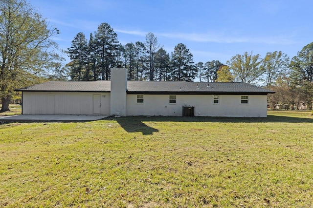 back of house featuring a yard and central air condition unit