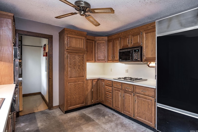 kitchen with concrete flooring, paneled refrigerator, stainless steel gas stovetop, and ceiling fan