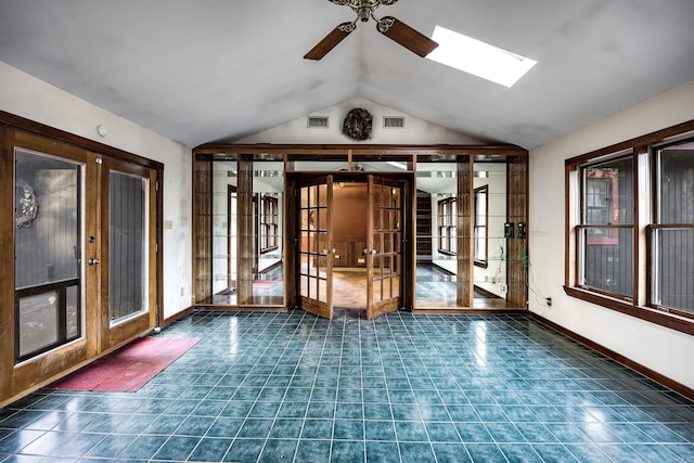 interior space with ceiling fan, lofted ceiling with skylight, and french doors