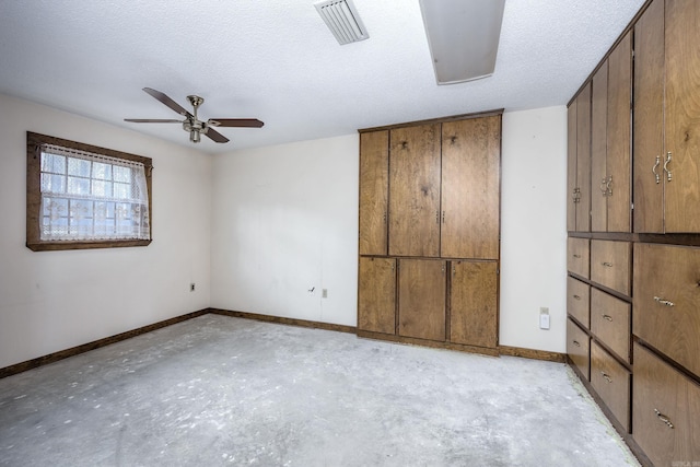 unfurnished bedroom with ceiling fan and a textured ceiling