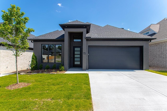 view of front of home with a garage and a front lawn